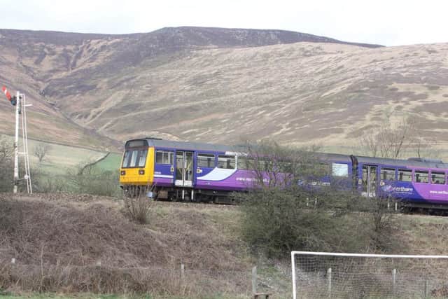 A train travels along the Hope Valley Line in the Derbyshire Peak District