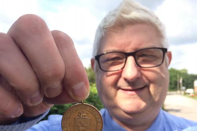 Alistair Lofley holds Harry Thorpe's medal. Picture: Hansons Auctioneers.
