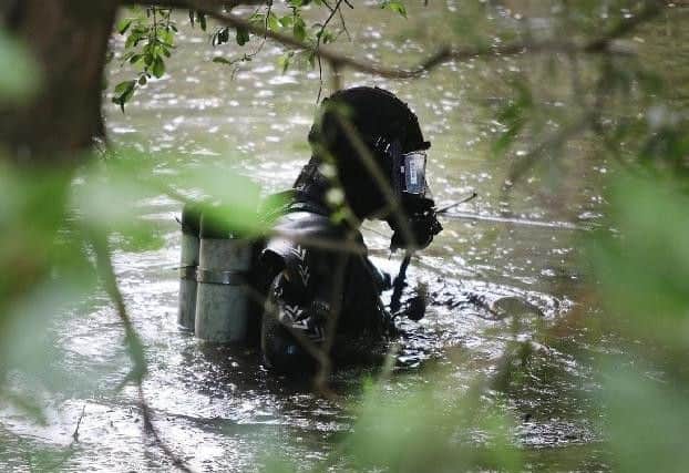 Police divers searching a pond in Newbold in July for the body parts of alleged murder victim Graham Snell.