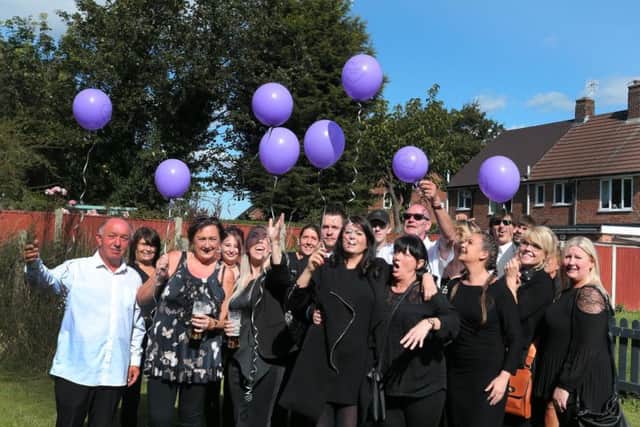 Family and friends of Philp Allen release balloons in his memory.