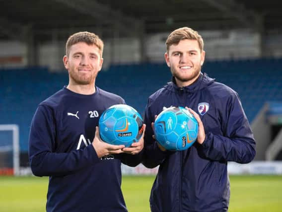 Sam Wedgbury and Laurence Maguire pictured with the one-off match ball which will be used on Saturday for Chesterfield's televised fixture against Notts County to raise awareness of prostate cancer.