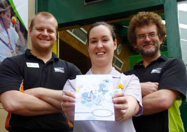 Pictured with Lee Rathbone (left) and Dave Pryor holding a thank you card from the Berrecloth family is receptionist Erica Power, who made the 999 call.