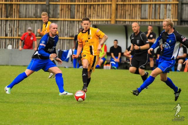 New Mills (yellow) in action against Ashton United in their final friendly of the summer.