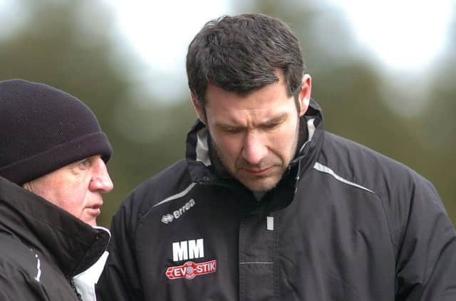 Buxton FC manager Martin McIntosh listens to Charlie Cresswell
