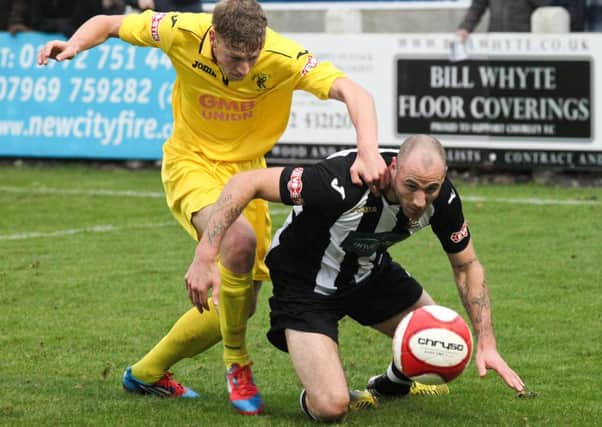 Matlock defender Adam Yates (left) tussles for possession during the clash at Chorley on Saturday in the FA Trophy, which the home side won 2-0. Photo/Chorley Guardian.
