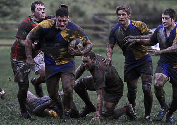 Matt Goodall (with ball) battles in the mud against Market Rasen. Photo by Colin Baker.