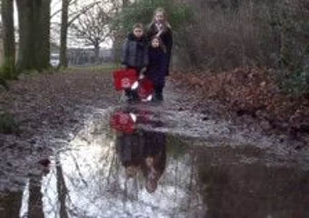 Wingerworth's Deer Park Primary School pupils Max and Mia Hudson with five-year-old Libby Dyson facing a water-logged walk to school.