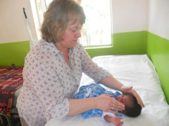 Helena Brown treating a child at the medical centre in Uganda. Photo contributed.