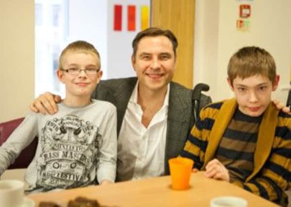 Sam Wright (r) with his brother Jacob and David Walliams at Rainbows Hospice