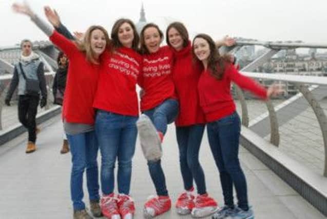 Participants of last year's Red Show Walk in aid of British Red Cross show of their red shoes. © BRCS 2014