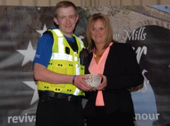 New Mills PCSO Will Brocket presenting Shellie Hagan with her award. Photo contributed.