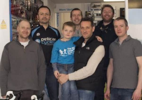 Pictured is Marcus Leverton and his son Harry, centre, with fellow bike riders at Pelican Cycles as they prepare for a 173 mile ride for the Sick Children's Trust.