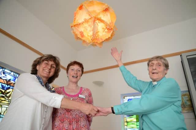 Blythe House Hospice arts day, artist Caro Inglis, Ann Burgoyne and Rev Betty Packham with the newly lit globe