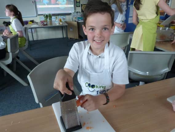 Arron Burgess, a year 6 pupil at Chapel Primary School, helps make rainbow wraps as the school takes part in Jamie Oliver's Food Revolution Day on Friday.