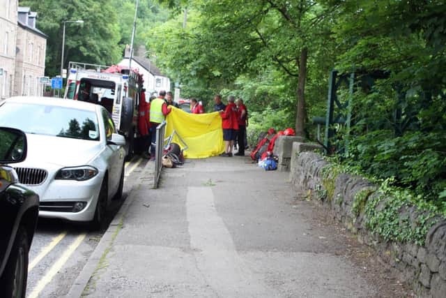 Mountain rescue staff hold up a sheet as the body is put into a waiting undertakers ambulance. Dale road Matlock.