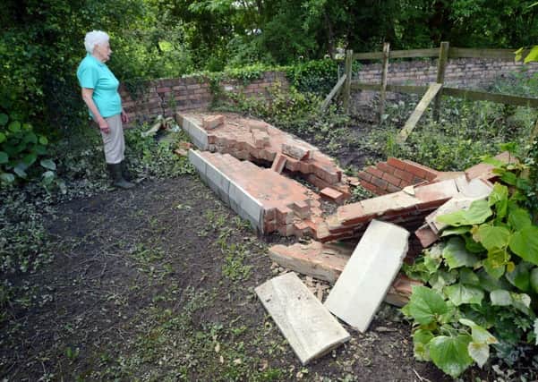 Duckmanton flood victim Marjorie Coupe looking at the damage done to her wall.