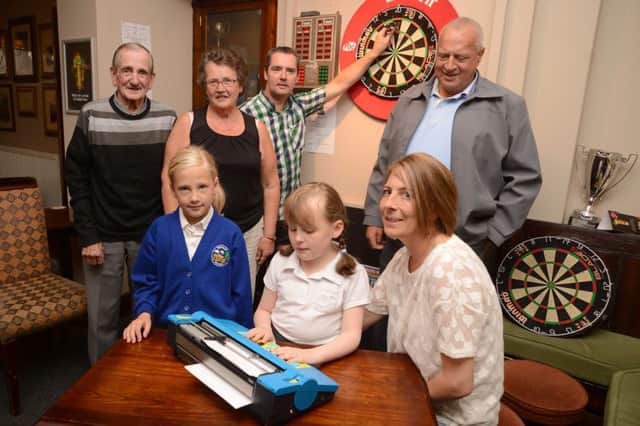 Sadie White accompanied by her sister Jody and mum Caroline is presented with a braille machine by Tommy Marsden, Tom Meehan, Jenny Webster and Mick Bishton reresenting the Ashford and District Darts League