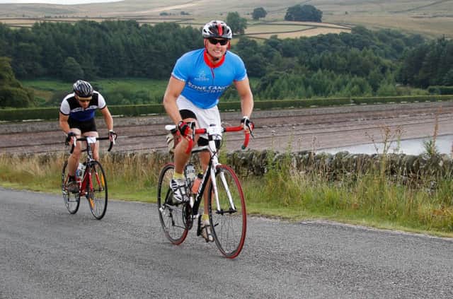 Cyclists on the Buxton Spa Sportive race past Errwood Reservoir. Photo by chrismeadsphoto.