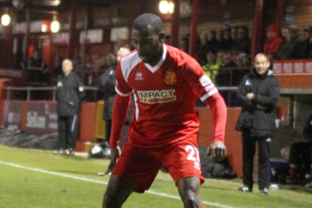 Alfretons Lathaniel Rowe-Turner is held up by Danny Harris.