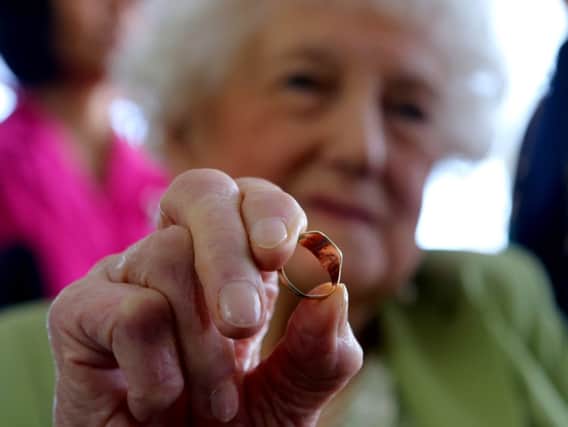 Dorothy Webster holds the ring of her dead brother 23-year old British pilot Sgt. John Thompson, in Tirana Monday, March 9, 2015 . Thompson crashed in Albania Oct. 29, 1944 while transporting materials to the local anti-Nazi partisan fighters. Sgt. John Thompson, a British World War II special operation pilot, was considered missing in action for more than 70 years. Not anymore. On Monday, his 92-year-old sister Dorothy Webster received his ring from a family in Albania together with a box of debris from his Halifax bomber that crashed in the eastern European country on Oct. 29, 1944 . (AP Photo/Hektor Pustina)