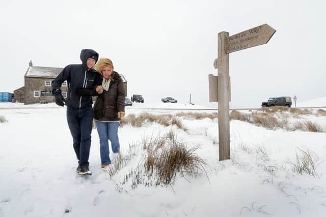 Michael Bruce, 24, with girlfriend Nicola Lennon, 23, brave the wintry condition for a short walk along the Pennine Way infront of Britain Highest pub the Tan Hill Inn, which stand at 1,732' (528m) above sea level in the middle of Arkengarthdale, in the Yorkshire Dales, National Park, on the edge of Yorkshire.