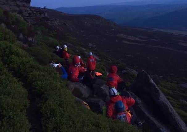Edale Mountain Rescue Team help a stranded climber at Dovedale Tor, Derwent Edge.