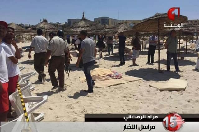 In this screen grab taken from video provided by Tunisia TV1, injured people are treated on a Tunisian beach Friday June 26, 2015. Two gunmen rushed from the beach into a hotel in the Tunisian resort town of Sousse Friday, killing at least 27 people and wounding six others in the latest attack on the North African country's key tourism industry, the Interior Ministry said. (Tunisia TV1 via AP MANDATORY CREDIT