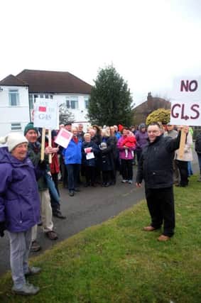 Protesters gather outside the house which sits on the corner of Diamond Avenue's juntion with Thoresby Avenue in Kirkby and is earmarked as a young people's home run by G4S.