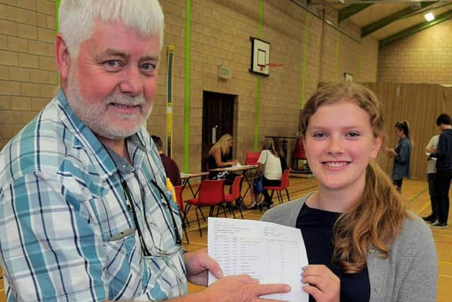 Students receiving their GCSE results in the Sports hall Alicia Fairburn aged 16, who achieved an incredible eleven  A* results, pictured with Head of year 11 Mike Basford. (2)