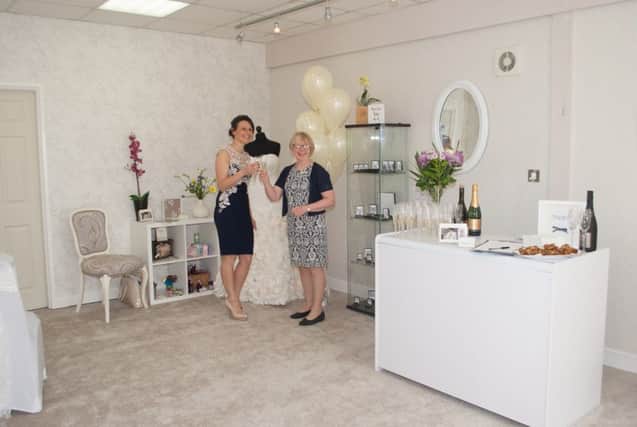 Katie Lyth opened House of Oliver Bridal Wear in Ilkeston after being shocked at the price of wedding dresses. She is pictured on the left alongside Erewash MP Maggie Throup, who cut the ribbon to open the new store.