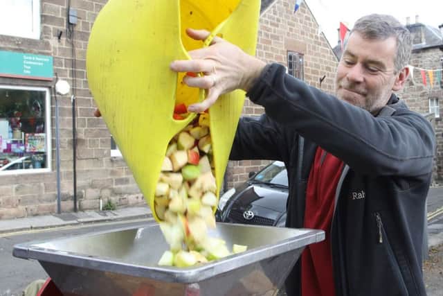 Cromford Apple Day, Chris Smartt loading apples into the mincer before juicing them