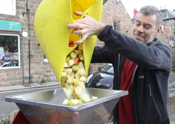 Cromford Apple Day, Chris Smartt loading apples into the mincer before juicing them