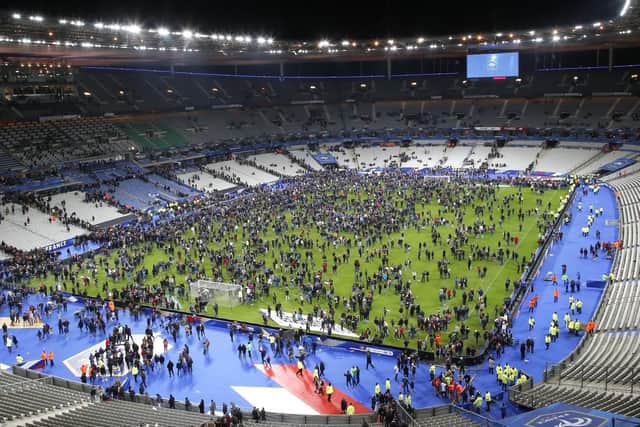 Spectators invade the pitch of the Stade de France stadium after the international friendly soccer France against Germany, Friday, Nov. 13, 2015 in Saint Denis, outside Paris.Two explosions were heard outside the Stadium, where French President Francois Hollande was watching the match.