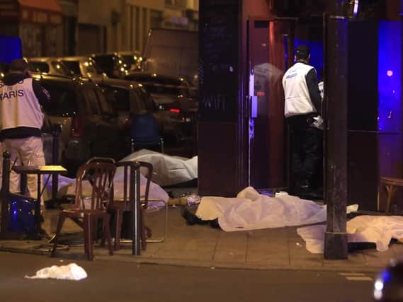 Victims lay on the pavement in a Paris restaurant, Friday, Nov. 13, 2015. (AP Photo/Thibault Camus)