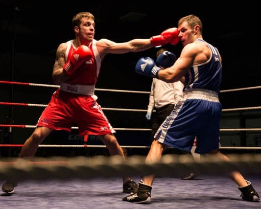 Sgt Howes (Blue), RAF Regiment competes against Rhys Banfield (red), RAF Regiment, during the RAF Boxing Asocsioation Chairty fight night held at RAF Coningsby. 
During the evening of Thursday 28 January, RAF Coningsby hosted a very special event in the 41 Squadron hangar. After months of planning, a Charity Boxing Night between the Royal Air Force (RAF), the Royal Navy (RN) and the Royal Regiment of Fusiliers (RRF) was ready to commence after the first ring of the bell.

Station Warrant Officer, Trevor Shippey and Cpl Pete Lownie had been planning this event for the last four to six months with representatives from the RN and the RRF. The evening consisted of ten bouts, with competitors weights ranging from 61  91 kilograms. WO Shippey explained the range of experience within the teams,

We had some elite and very experienced boxers, including the Combined Service Champion, but there were also some boxers who were stepping through the ropes and into the ring for the first time.

In the RAF team, there was