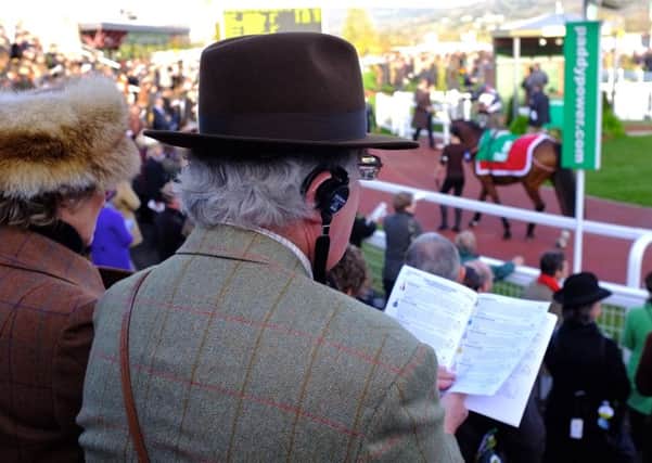 STUDYING THE FORM AT CHELTENHAM -- keen paddock-watchers using their eyes and ears in search of winners at last years Cheltenham Festival. (PHOTO BY: www.horseracingphoto.co.uk).
