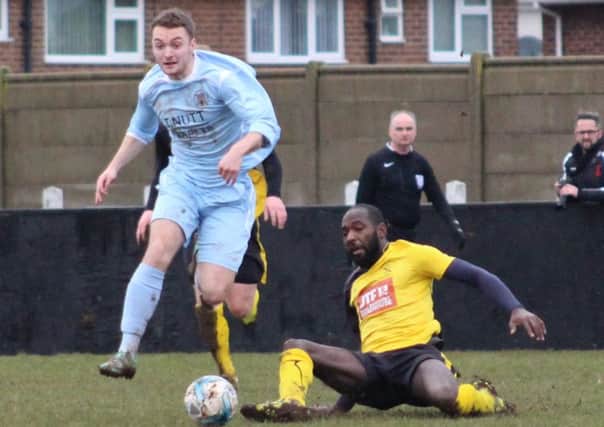 EASY RIDER -- Ben Goodwin, of Clay Cross, rides a tackle by Hucknall Town's Kajally Danso.