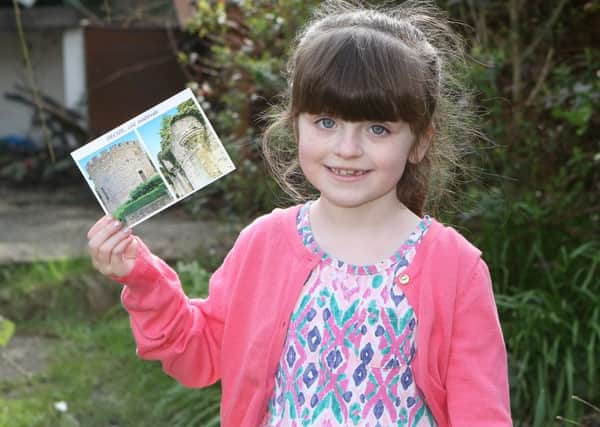 Seren Roome with the postcard from France after launching a balloon in Ilkeston