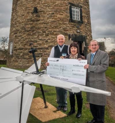 Piers Bostock (Chair of Heage Windmill Society) with Angela Ward, ( Chair Friends of  Windmill) and John Kirkland MD of Bowmer and Kirkland, holding the cheque for Â£10,000 donated by Bowmer and Kirkland to help with the repair of the windmill.