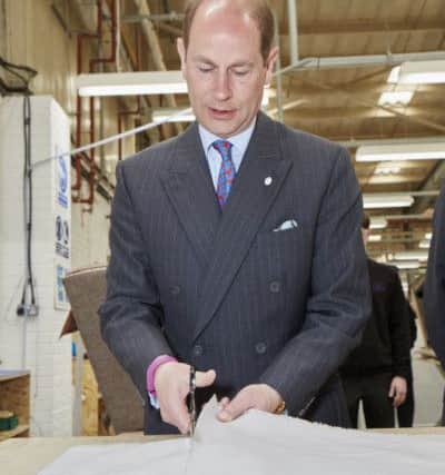 HRH tries his hand at fabric cutting.