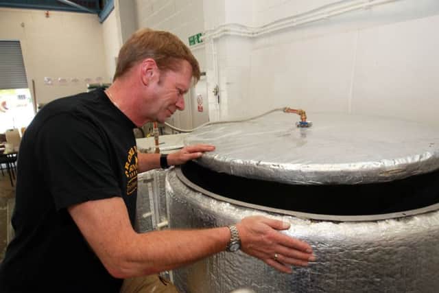 Jez checks one of the brewing tanks.