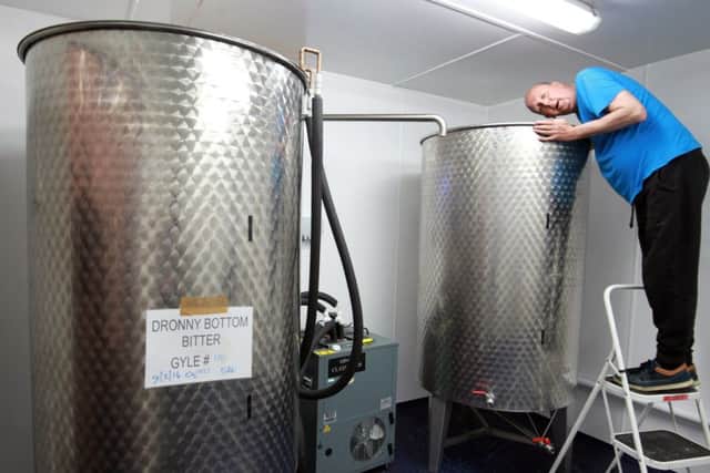 Nick Williams with the fermentation tanks.