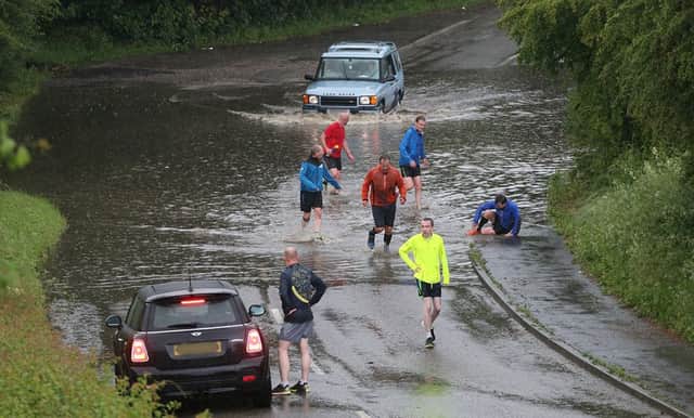 Ripley Running Club battling through the flooded road on Street Lane near Heage.