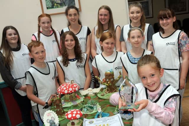 Daisy Hibbs a member of the Wingerworth Kids Sugarcraft Club, holds aloft their international trophy for their creations.