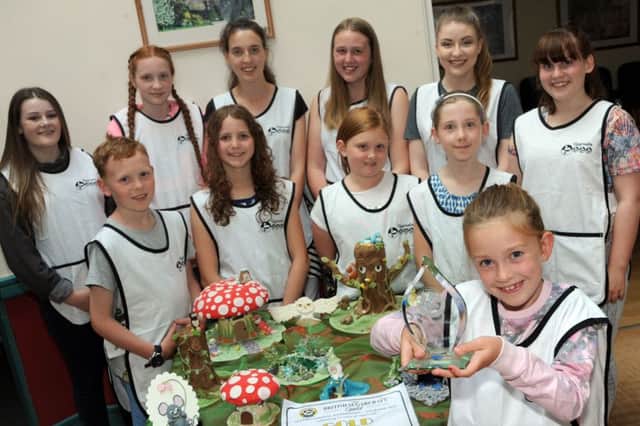 Daisy Hibbs a member of the Wingerworth Kids Sugarcraft Club, holds aloft their international trophy for their creations.