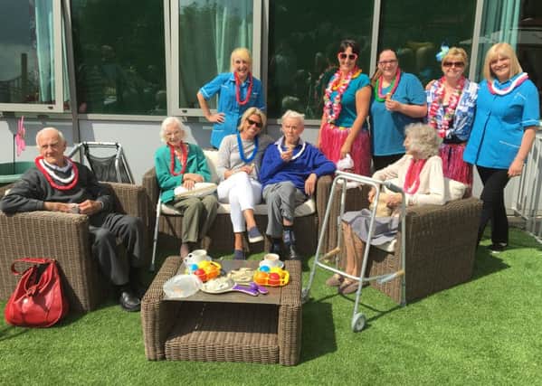 Residents and staff enjoying the beach party in the rooftop garden at Spencer Grove Care Home.