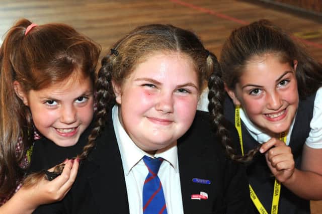 Millie-May Leder gets some support for her sponsored head shave from twin sisters, Jorja and Sophie.