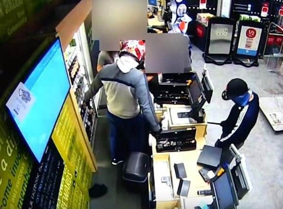 One robber was shown on CCTV to intimidate a staff member who seemed to resist opening the till.