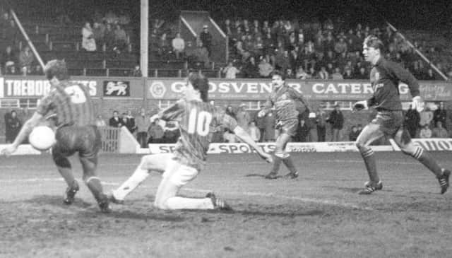 John Clayton, scorer of one of the Chesterfield goals, is denied another when Dave Burgess, the Rovers left-back, uses an arm to prevent a goal.