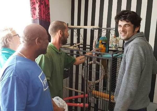 Jake Metcalfe (far right) with his macaw parrot after it was rescued.